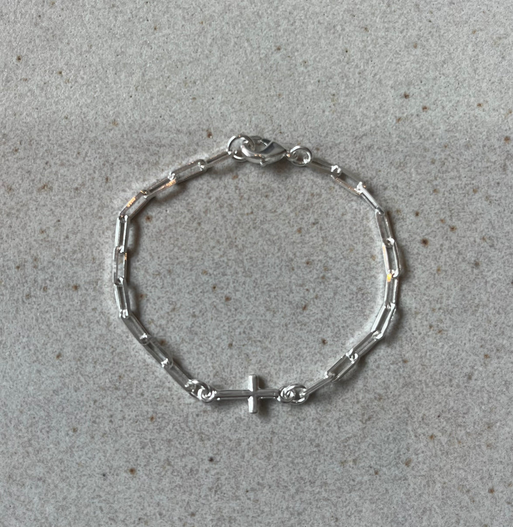 Pulsera de niña cadena cartier con conector de cruz. Bronce enchapado en plata. 16cm (R17)